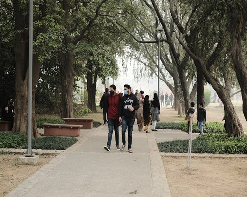 Happy senior indian couple walking in park holding hands